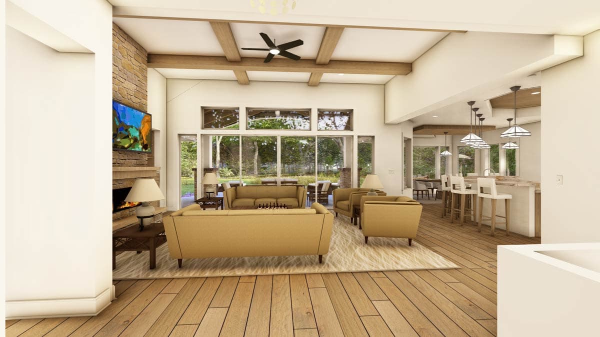 Living room with stone fireplace, vaulted beamed ceiling, and open kitchen with island and pendant lights.