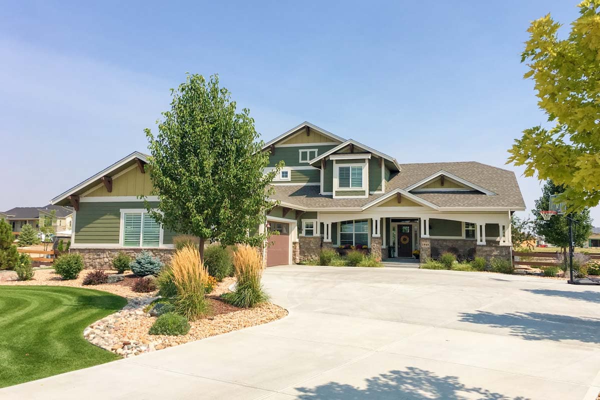 House plan exterior: Craftsman style, two stories, with a prominent covered front porch, multiple gables, and a side-facing garage.