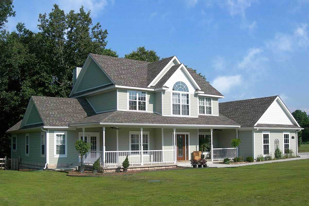 House plan exterior: Two-story with wraparound porch, gables, dormers, and arched second-story window.