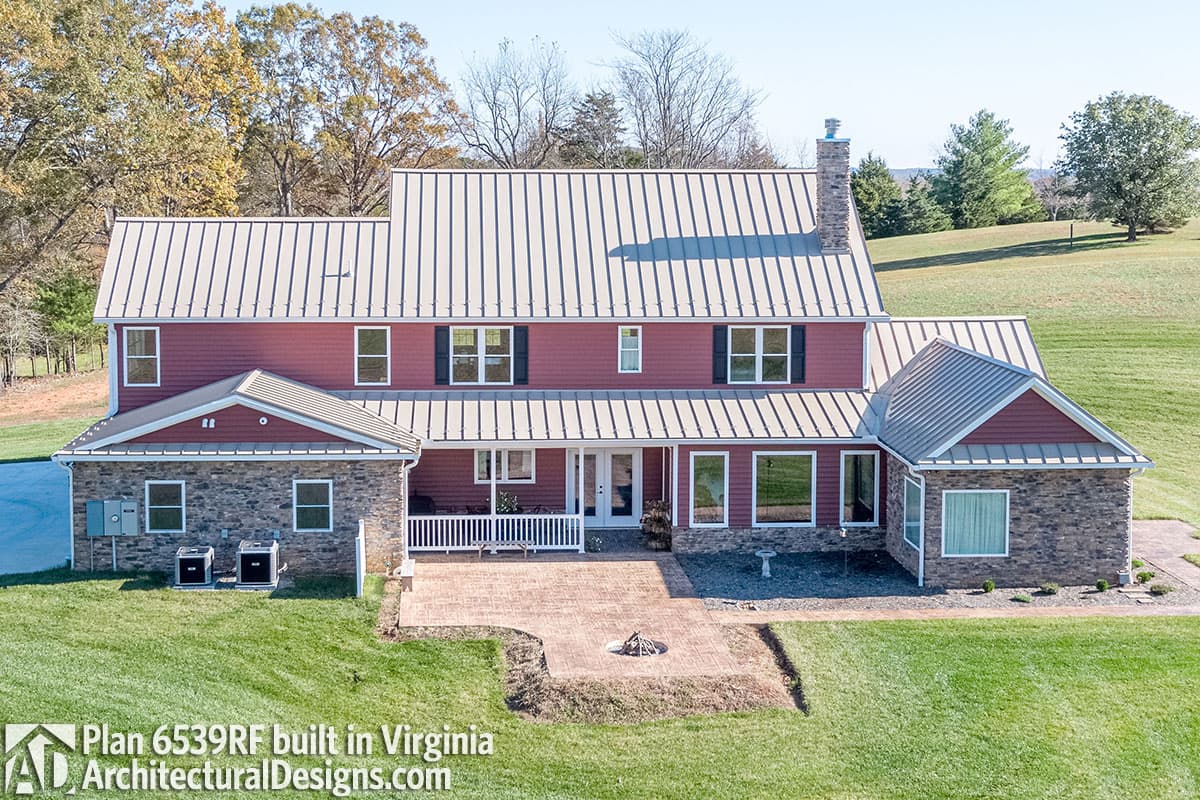 Two-story house plan exterior with stone foundation, gabled roofs, dormers, and covered front porch. Plan 6539RF.