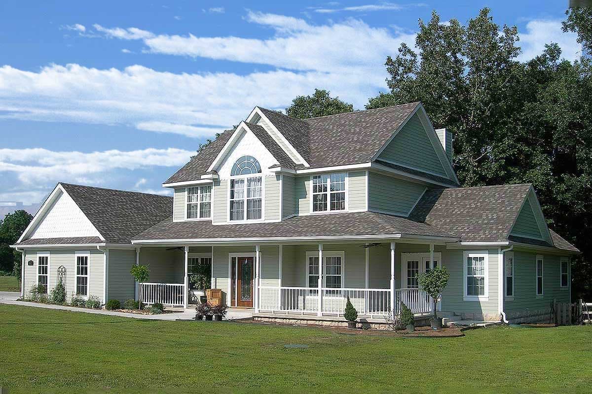 Two-story house plan exterior with wraparound porch, arched dormer window, and gabled roof.
