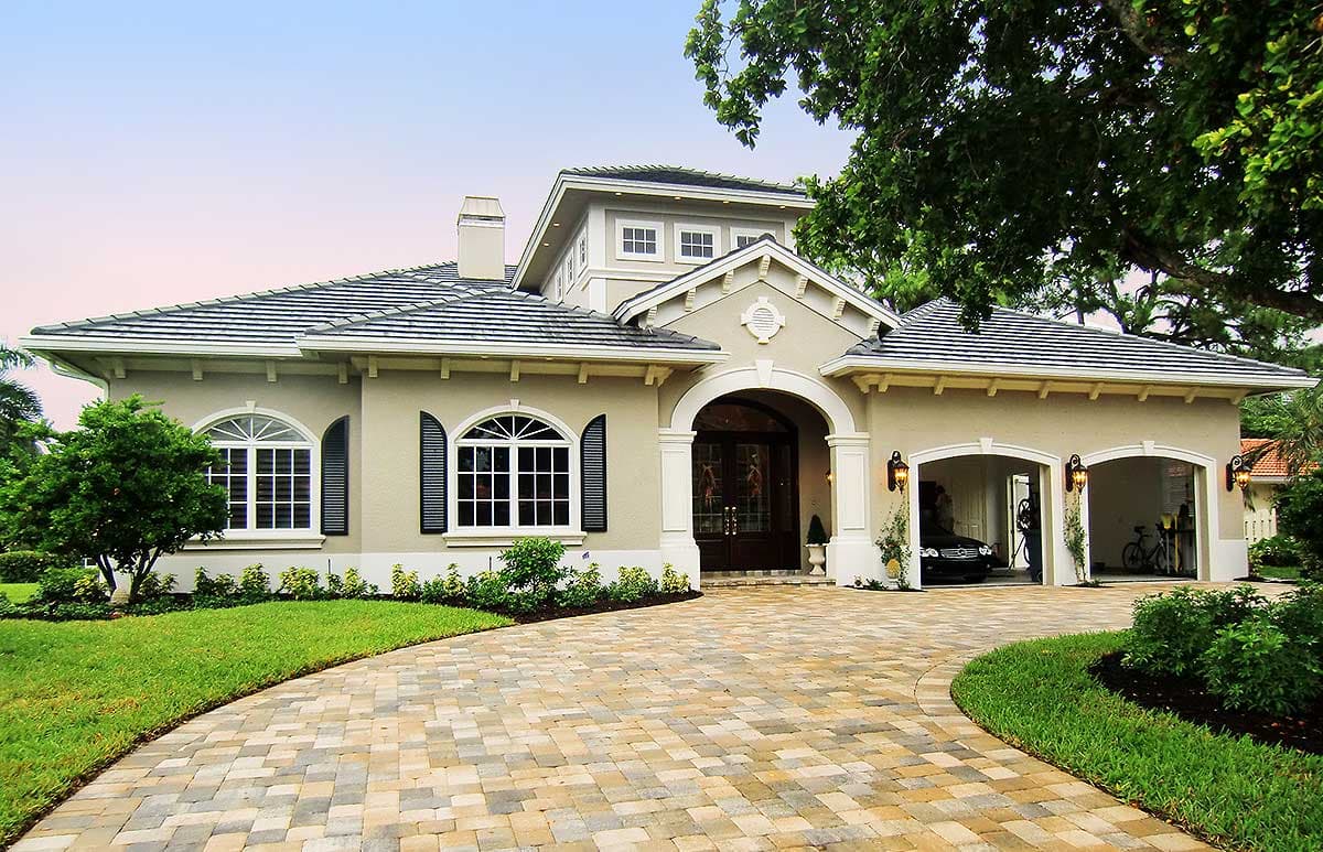 House plan exterior: Spanish-style, one-story residence with arched entryway, multiple gables, tile roof, and attached three-car garage.