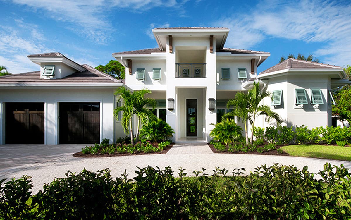 Modern house plan exterior with a three-car garage, prominent central entryway, covered balcony, and hip rooflines.