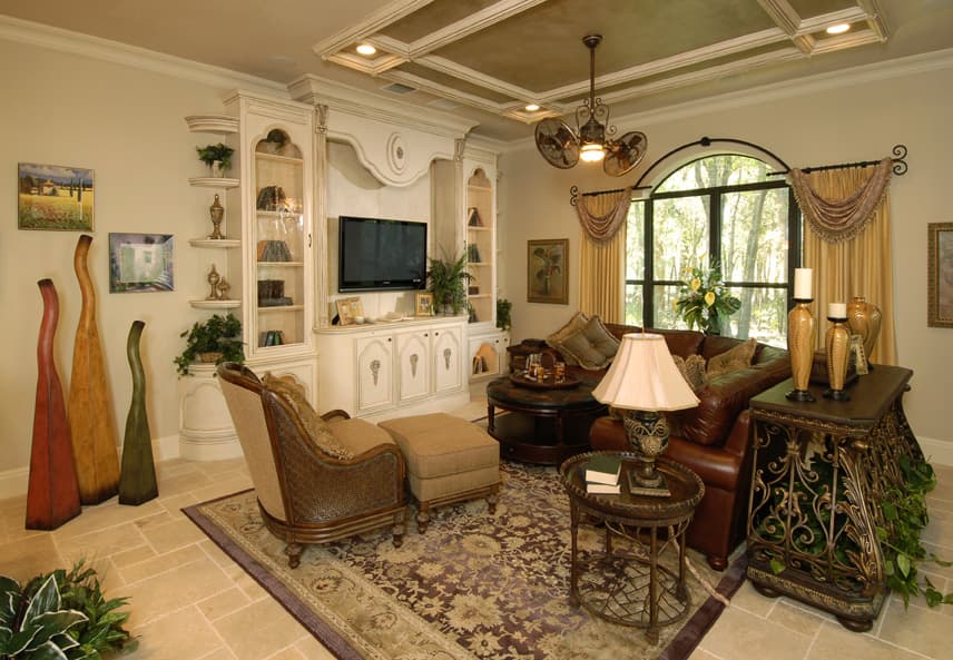 Living room with coffered ceiling, built-in entertainment center, and arched window.