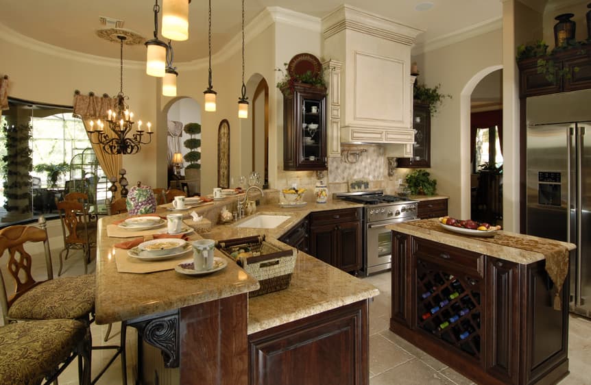 Kitchen with granite counters, dark wood cabinets, stainless steel range, and island with wine rack.