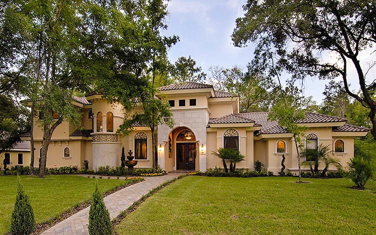 House plan exterior: Mediterranean style, two stories, arched entry, turret, and tile roof.