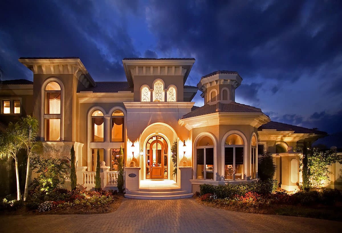 House plan exterior showing a two-story Mediterranean-style home with arched windows, a central arched entryway, and a domed turret.