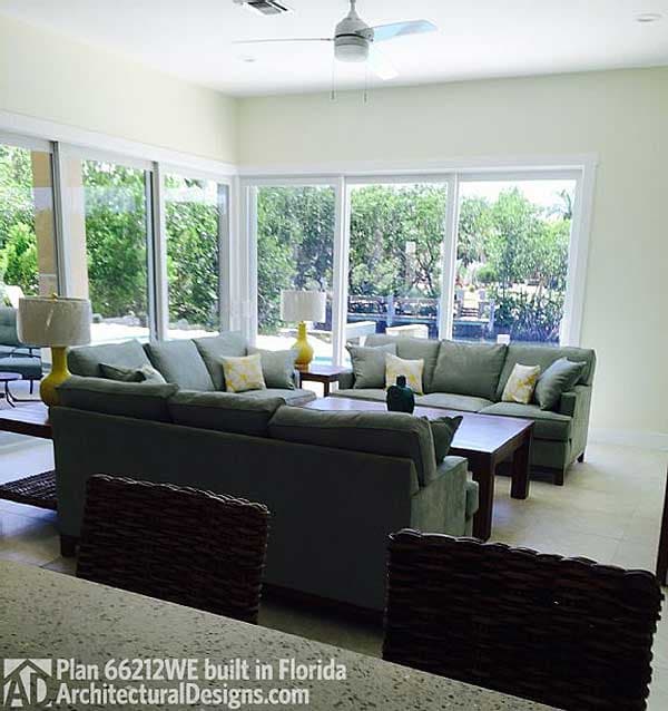 Living room with sectional sofas, coffee table, and large windows overlooking an outdoor area.