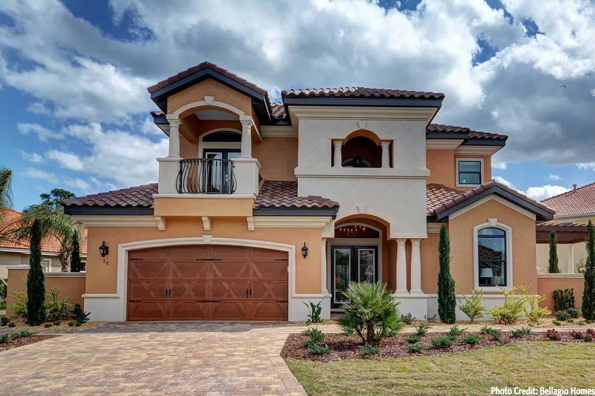 House plan exterior. Two-story Mediterranean style with arched entryway, Juliet balcony, tile roof, and a two-car garage.