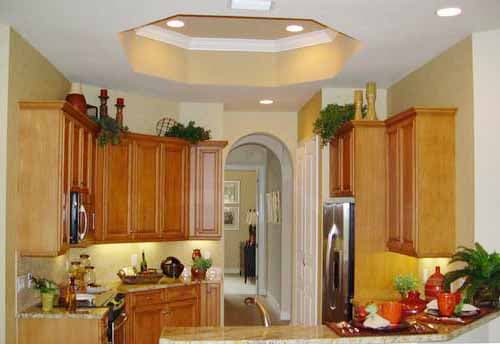 Kitchen with light wood cabinets, granite countertops, stainless steel refrigerator, and octagonal coffered ceiling.