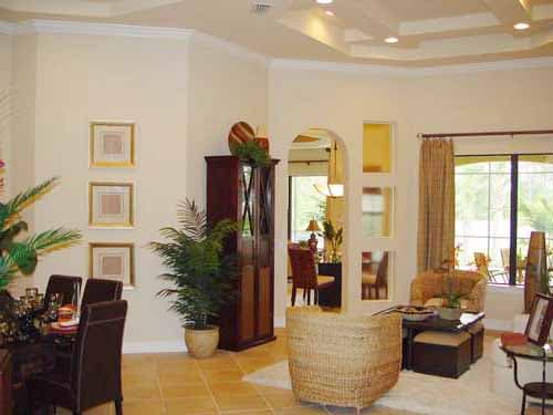 Interior rendering of a living room with a tray ceiling, archway, and large windows.