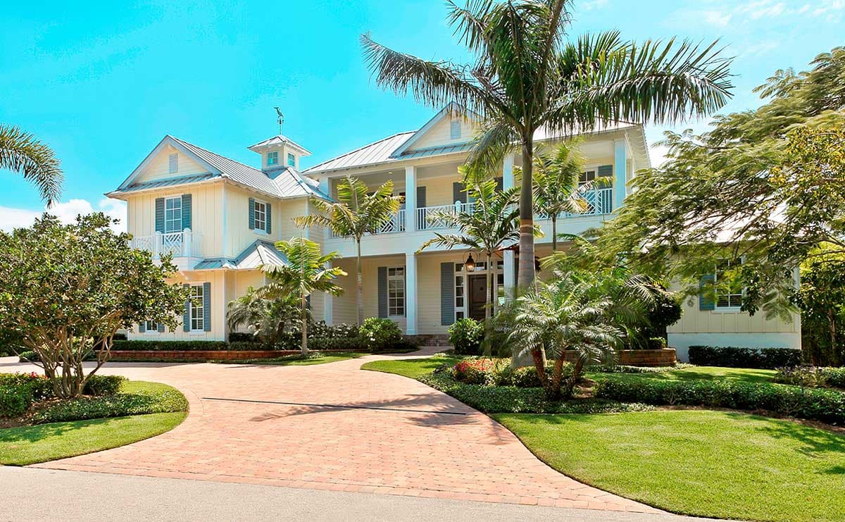 House plan exterior: two-story Coastal style with wraparound porch, dormers, gables, and metal roof.