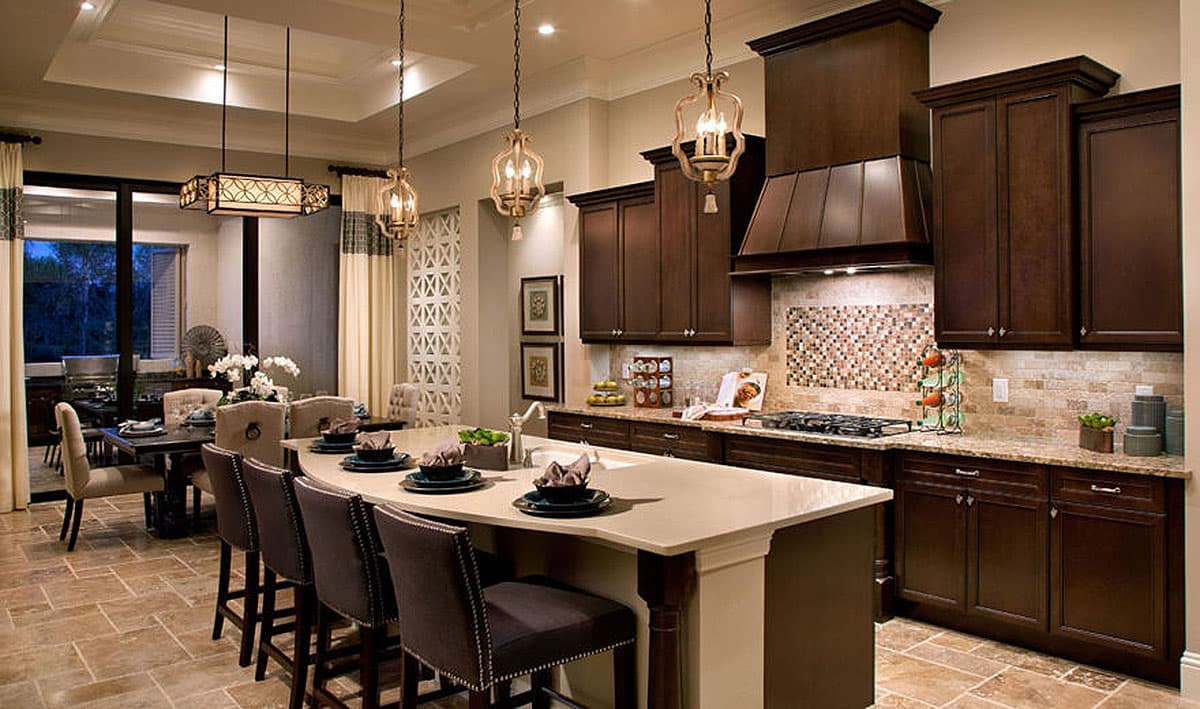 Kitchen with island, dark wood cabinetry, granite countertops, mosaic tile backsplash, and dining area.