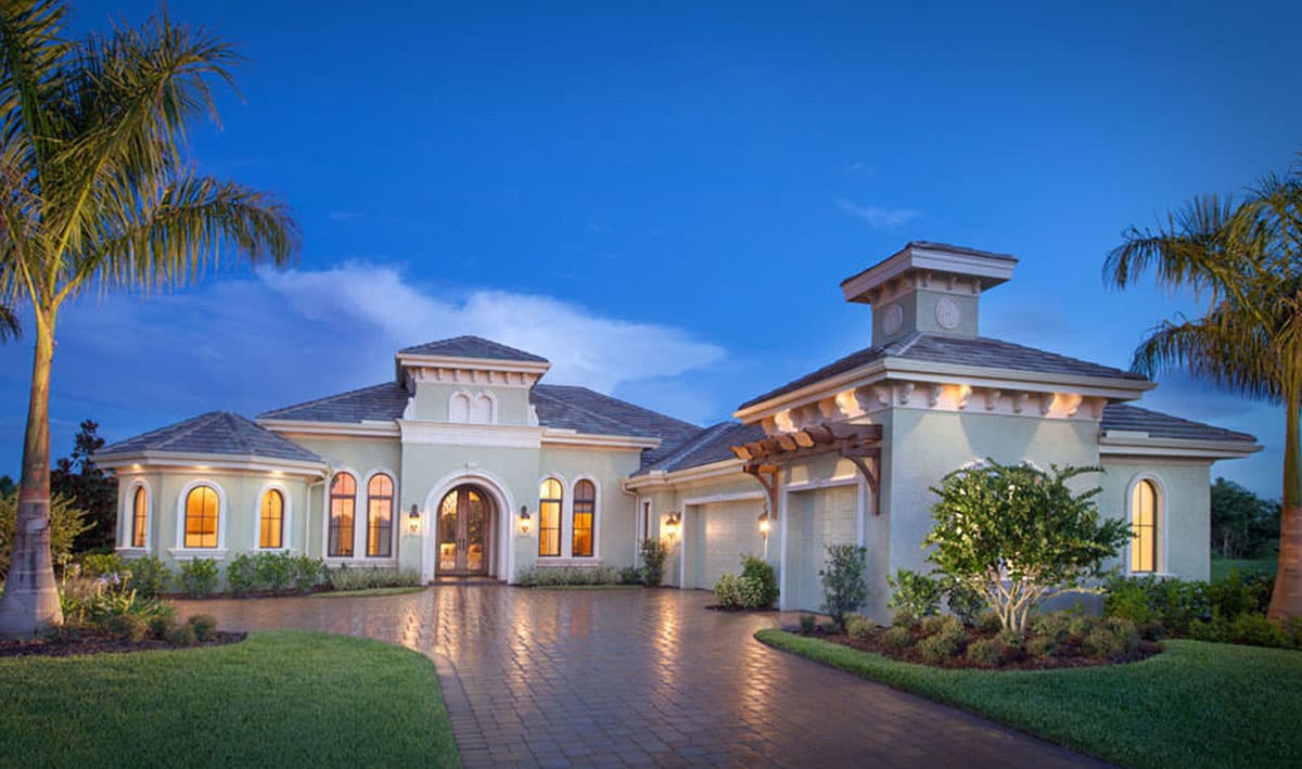 House plan exterior featuring Mediterranean architecture. Single-story with barrel tile roof, arched windows, and attached garage with pergola.