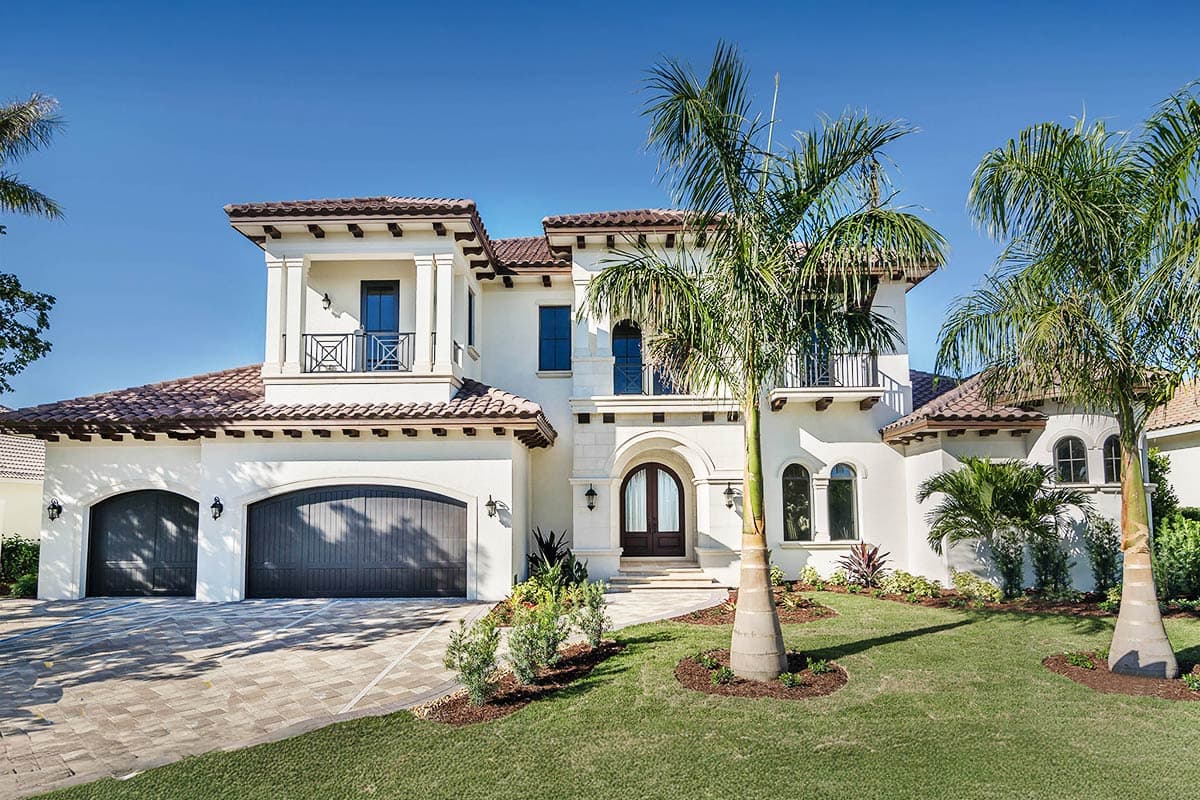 House plan exterior with Mediterranean style, two stories, arched garage doors, and balconies.