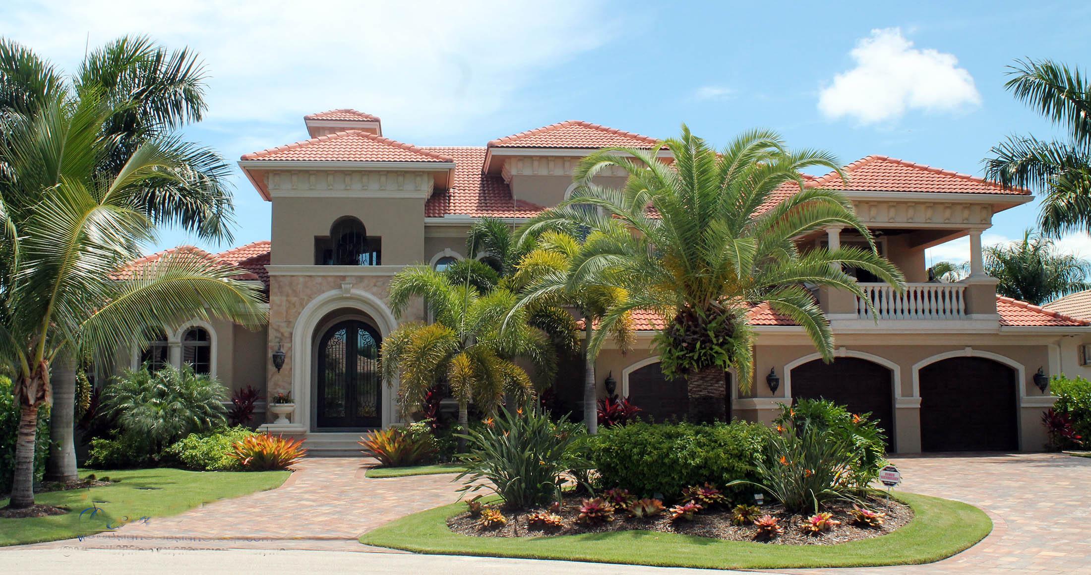 House plan exterior: Mediterranean style, two stories, red tile roof, arched entry, and three-car garage.