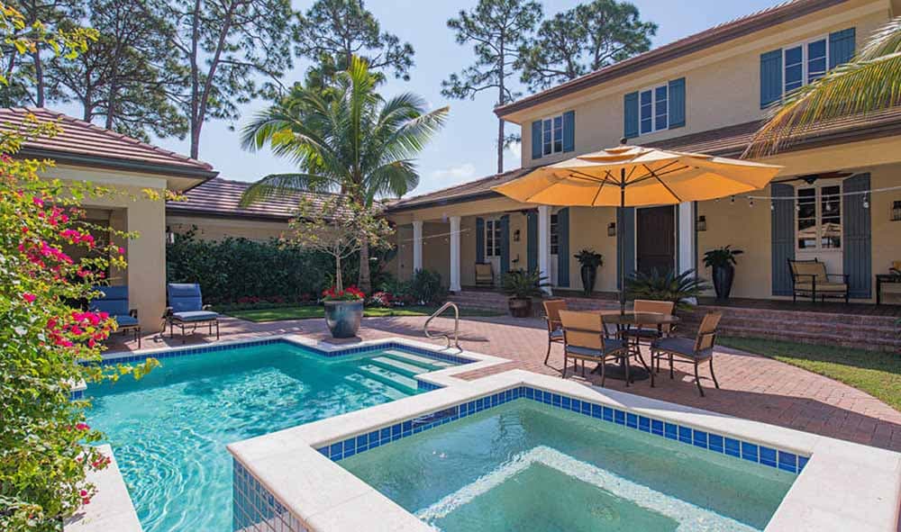 House plan exterior shows a two-story home with a covered porch, tile roof, and attached courtyard with a swimming pool and spa.
