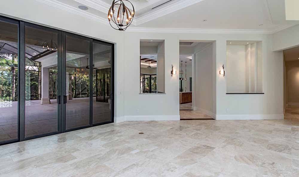 Interior view of a great room with large sliding glass doors, pass-through window to kitchen, and decorative niches.