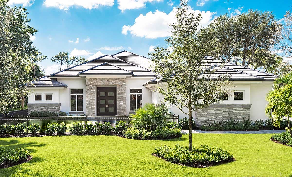 House plan exterior with stone accents, hip roof, and a dark front door. Single-story with manicured lawn and landscaping.