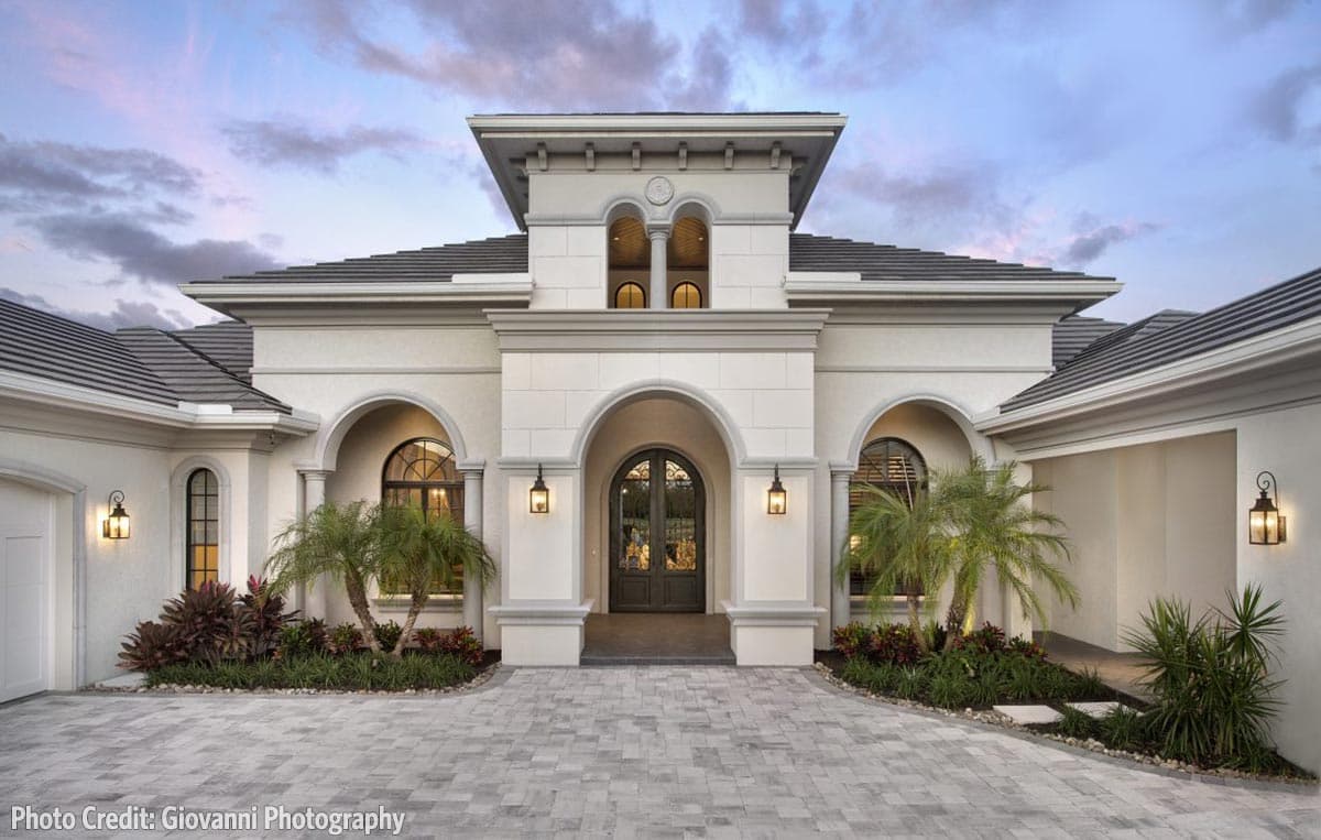 House plan exterior. One-story Mediterranean style with arched entryway, decorative facade, and tiled roof.