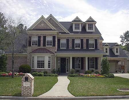 Two-story brick house plan with dormers, multiple gables, a covered porch, and an attached side-entry garage.