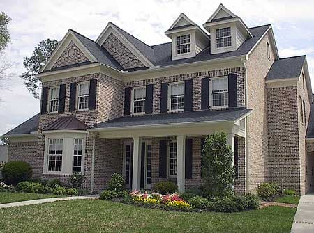 Two-story brick house plan exterior with a covered porch, bay window, and multiple gables with dormers.