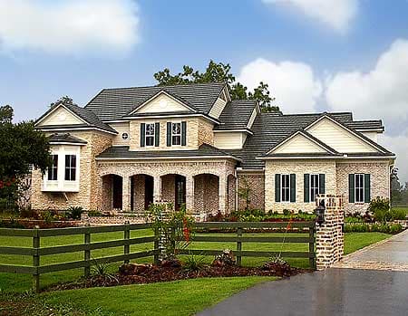 House plan exterior featuring a two-story home with a brick facade, arched entryway, multiple gables, and a bay window.