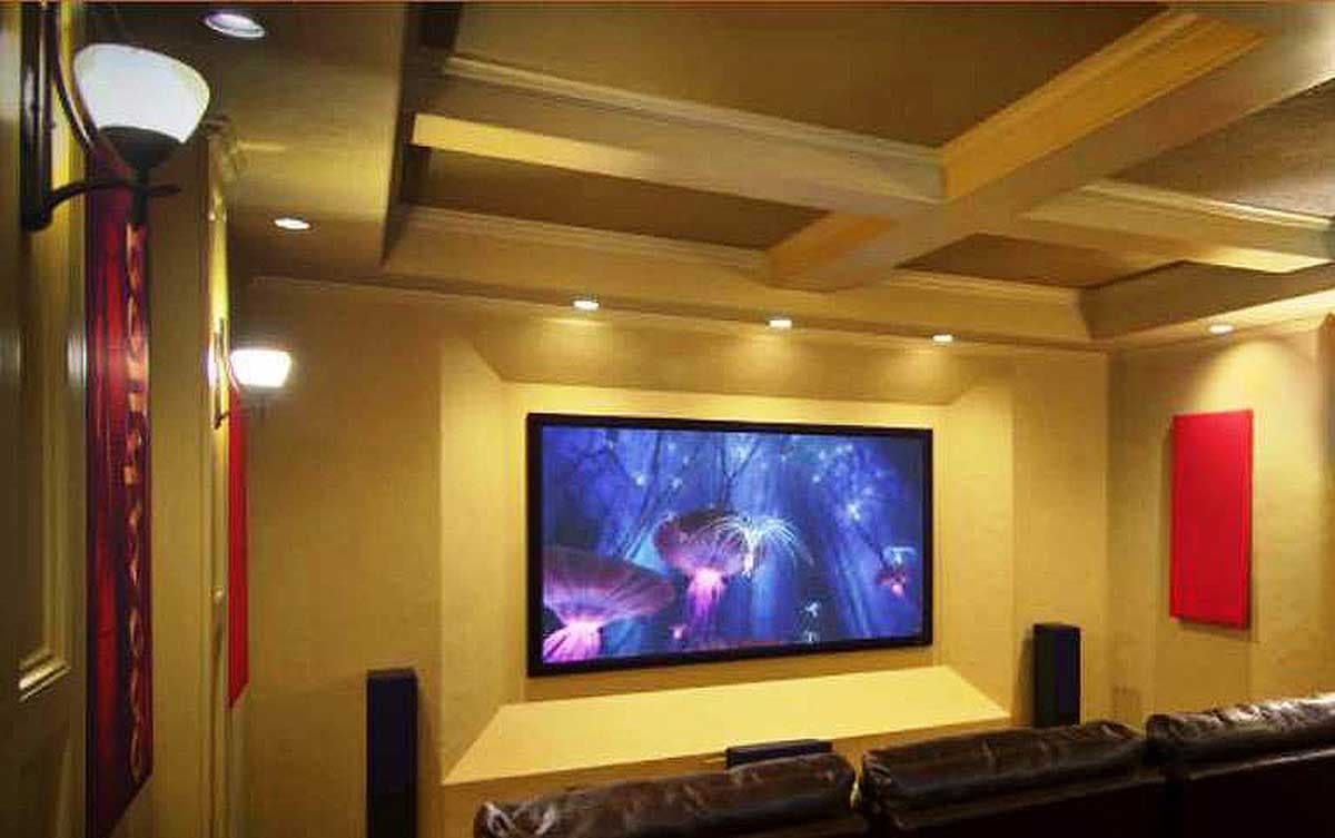 Home theater room with coffered ceiling, recessed lighting, large screen, and leather seating.