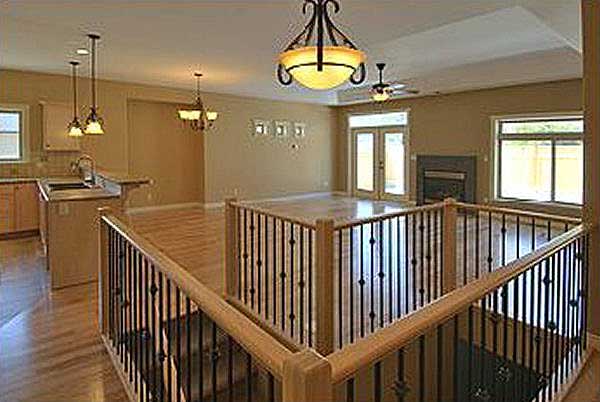 Open concept living area with kitchen, fireplace, double doors to outside, and vaulted ceiling.
