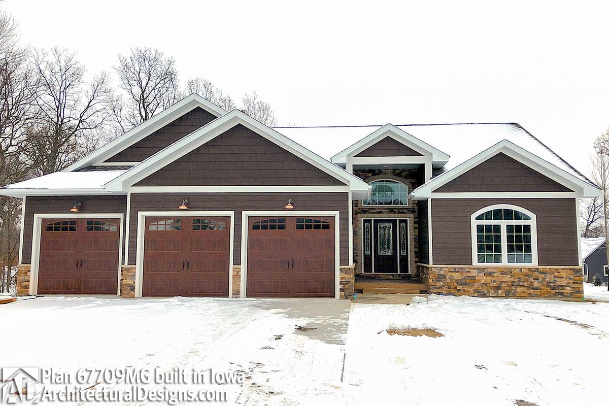 House plan exterior: Modern home with three-car garage, prominent gables, stone accents, and arched entry.