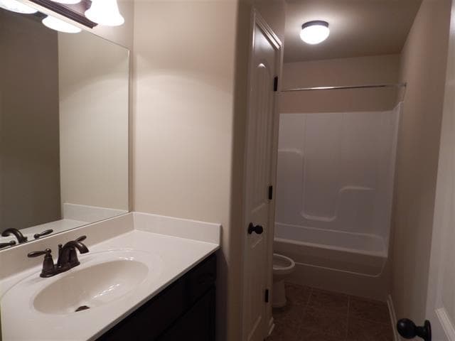 Bathroom with vanity, mirror, toilet, and white bathtub/shower combo.