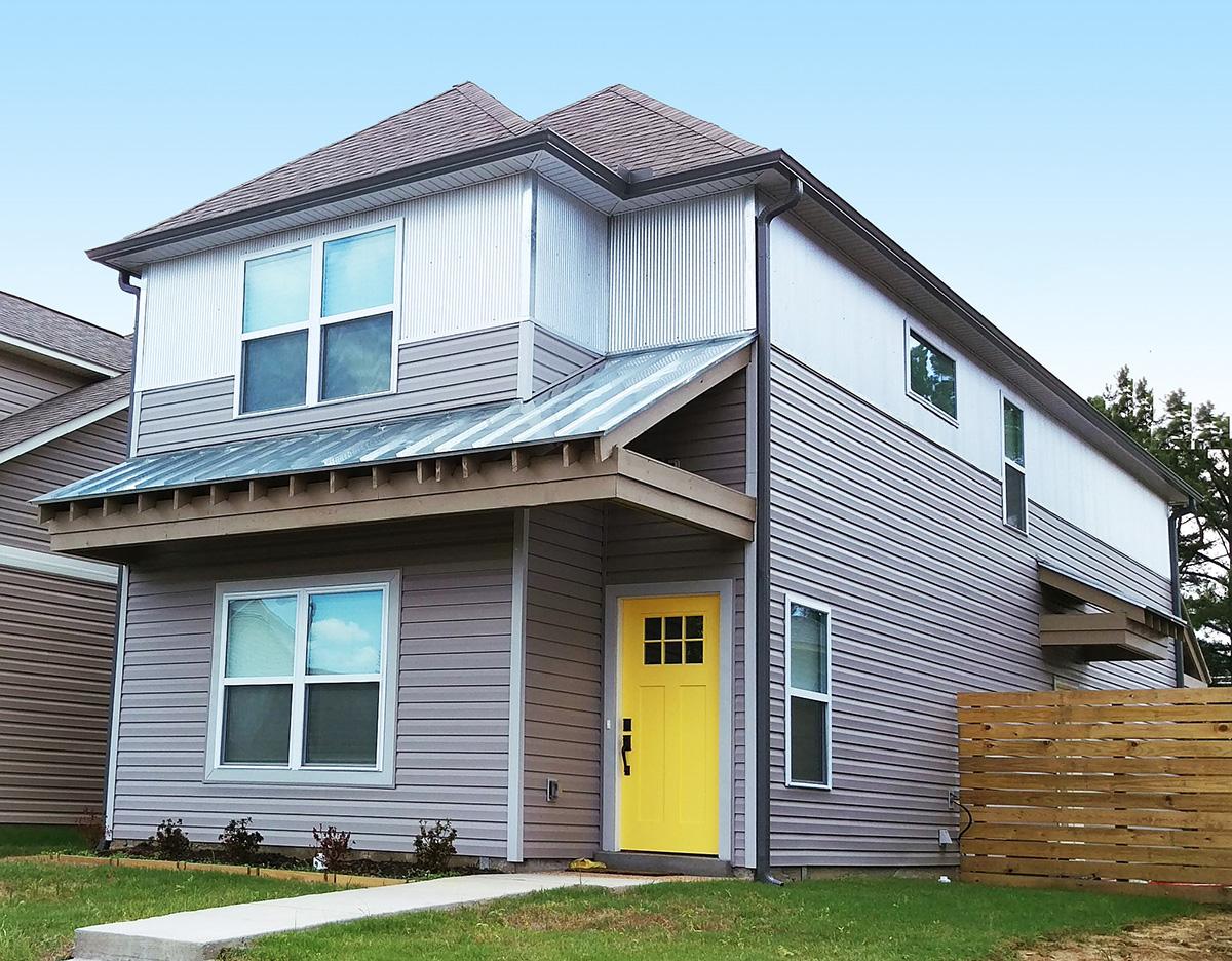 Two-story house plan exterior with horizontal siding, corrugated metal accents, a sloped metal roof, and a bright yellow front door.