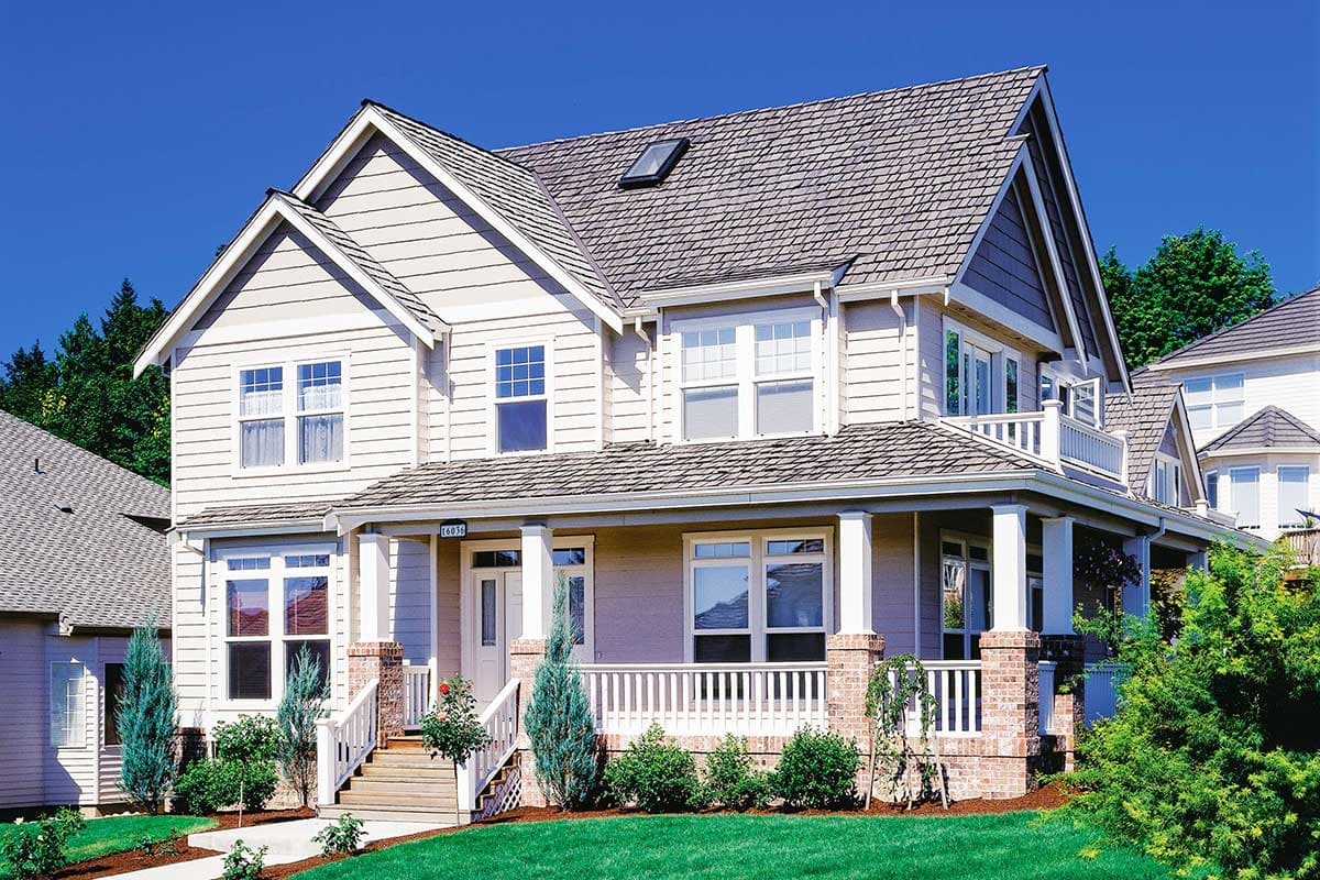 House plan exterior: Two-story home with a wraparound porch, prominent gables, and a dormer window.