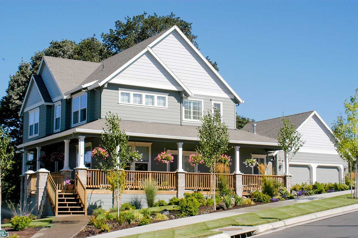 House plan exterior: Two-story home with wrap-around porch, gables, and attached three-car garage.