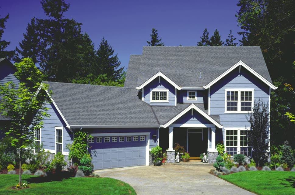 House plan exterior: two-story blue siding home with gables, dormers, covered entry, and attached two-car garage.