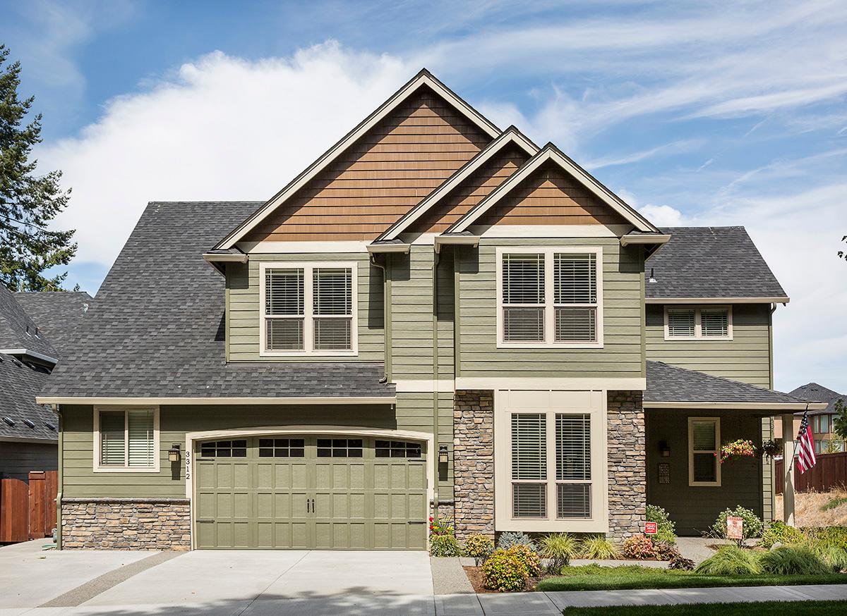 Two-story house plan exterior with siding, stone accents, dual gables, dormers, and attached garage.
