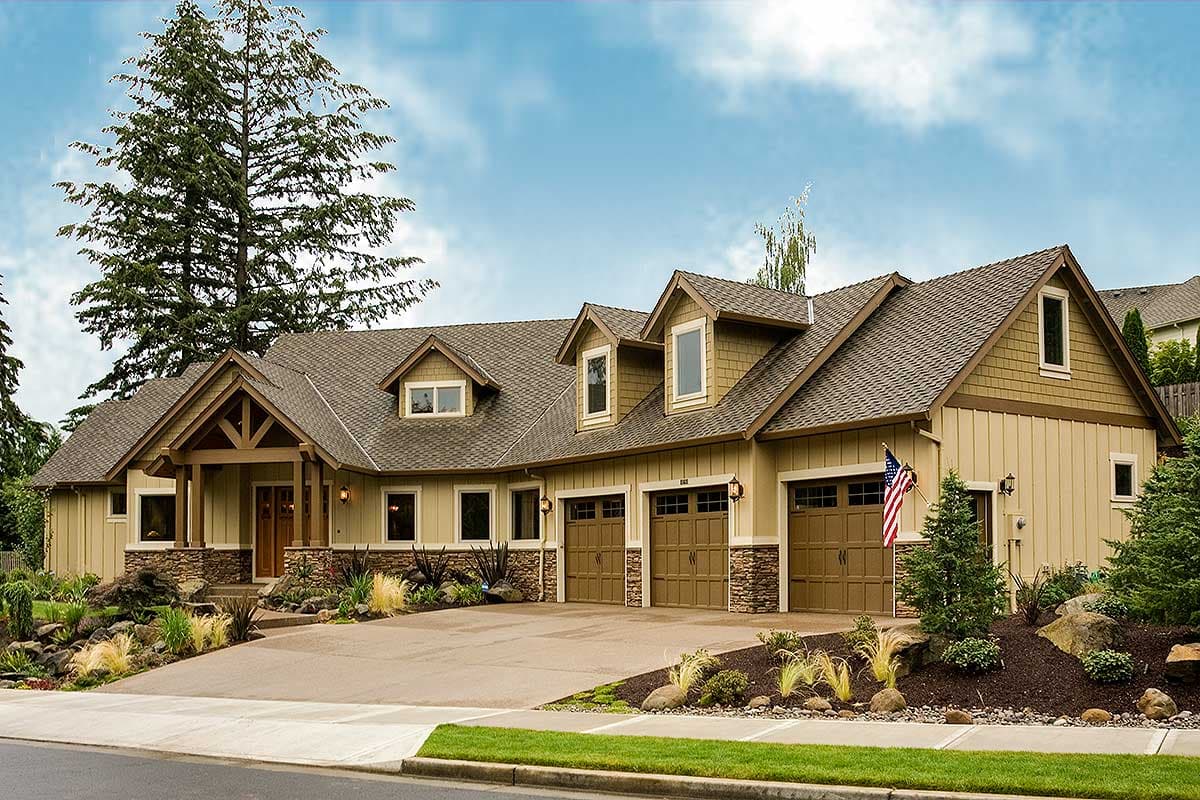 Craftsman style house plan exterior with exposed rafter tails, stone accents, dormers, and a triple garage.