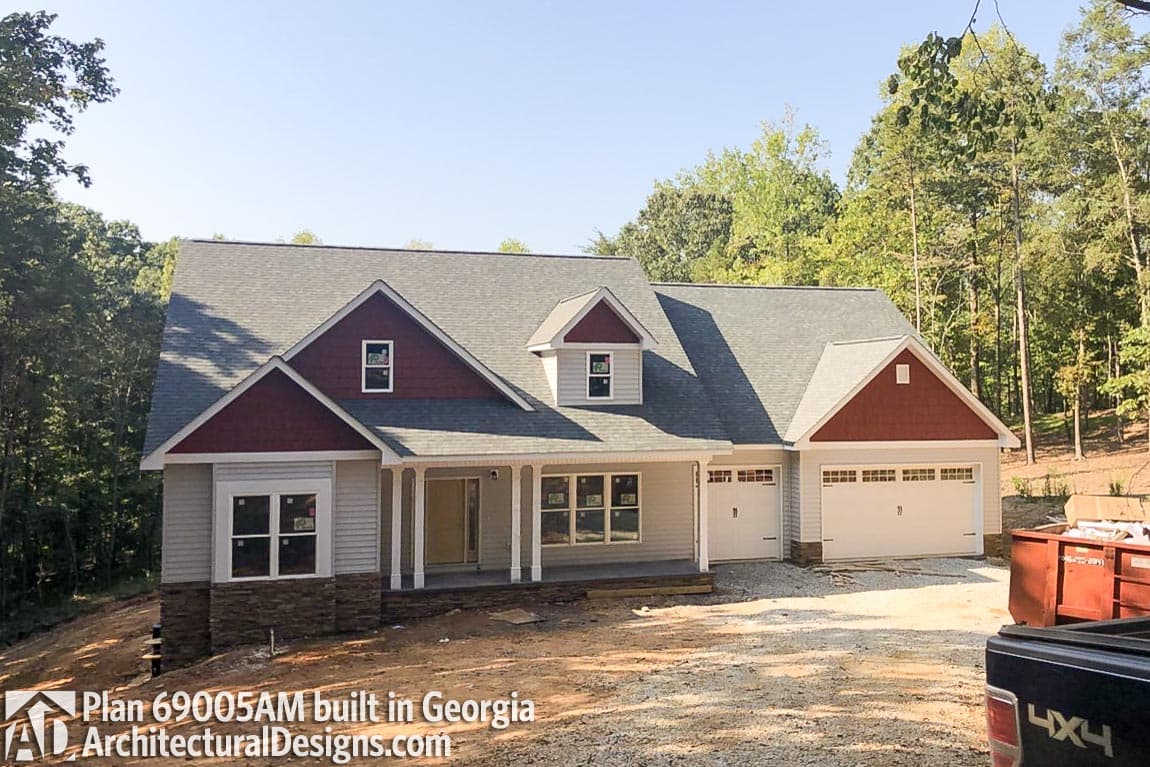 House plan exterior: one-story Modern Farmhouse with gabled dormer, covered porch, and attached three-car garage.