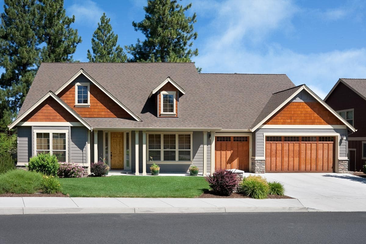 House plan exterior: Craftsman style, two stories, with prominent gables, wood shingle siding, and a covered front porch.