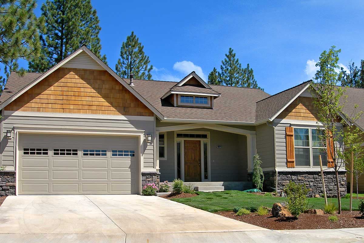 House plan exterior: Ranch style, one-story with attached garage, shingle gable accent, dormer, and covered entry.