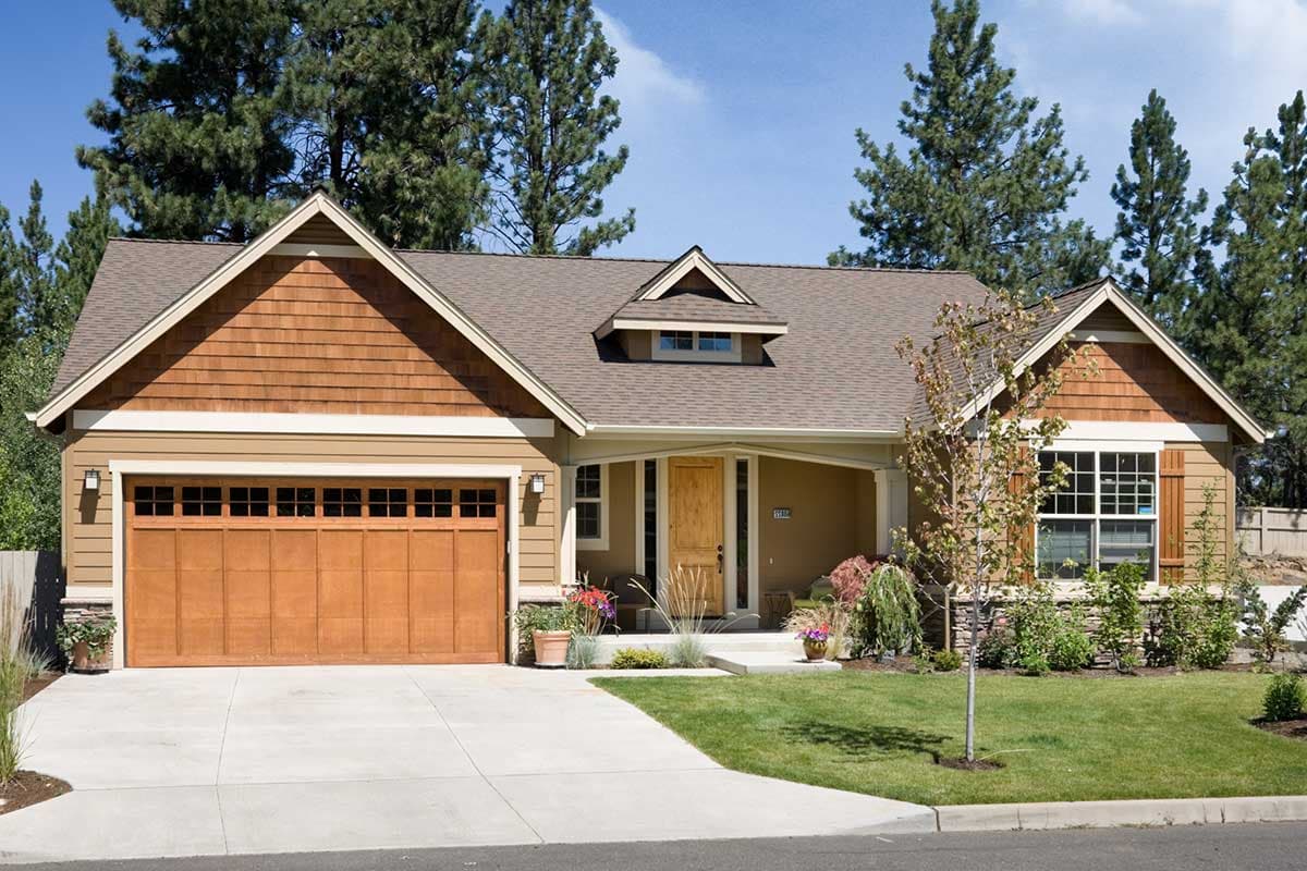House plan exterior: Craftsman style, one story, with a gable, dormer, covered porch, and attached garage.