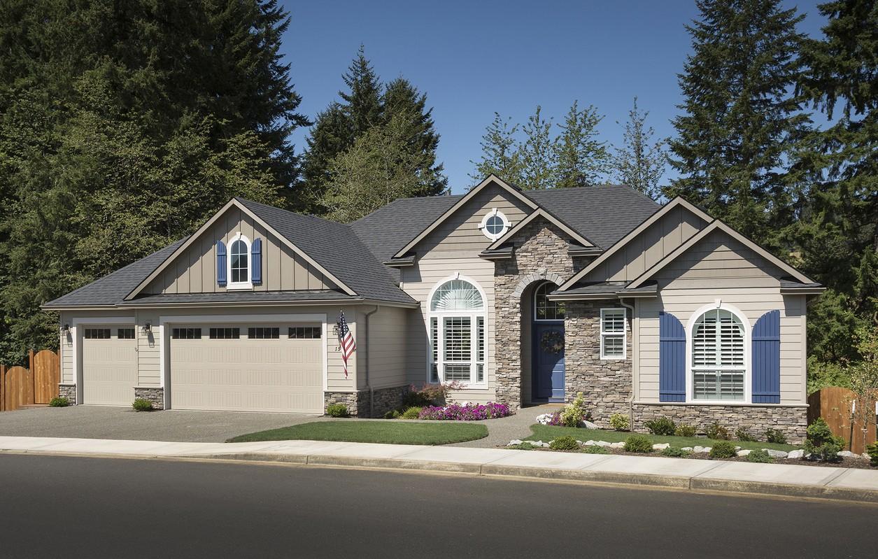 House plan exterior: Ranch style, tan siding, stone accents, arched entryway, large arched windows, and a three-car garage.