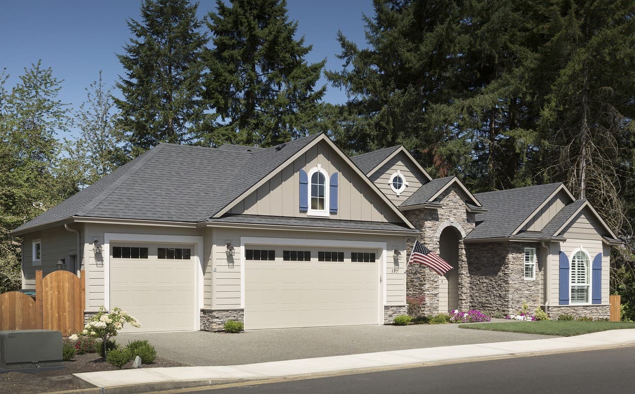 House plan exterior with three-car garage, arched stone entry, dormers, and gables.