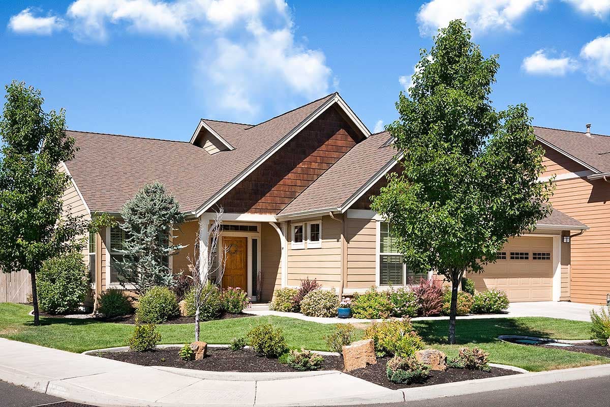 House plan exterior: Ranch style, one story, with a prominent gable, shingle siding accent, and attached garage.