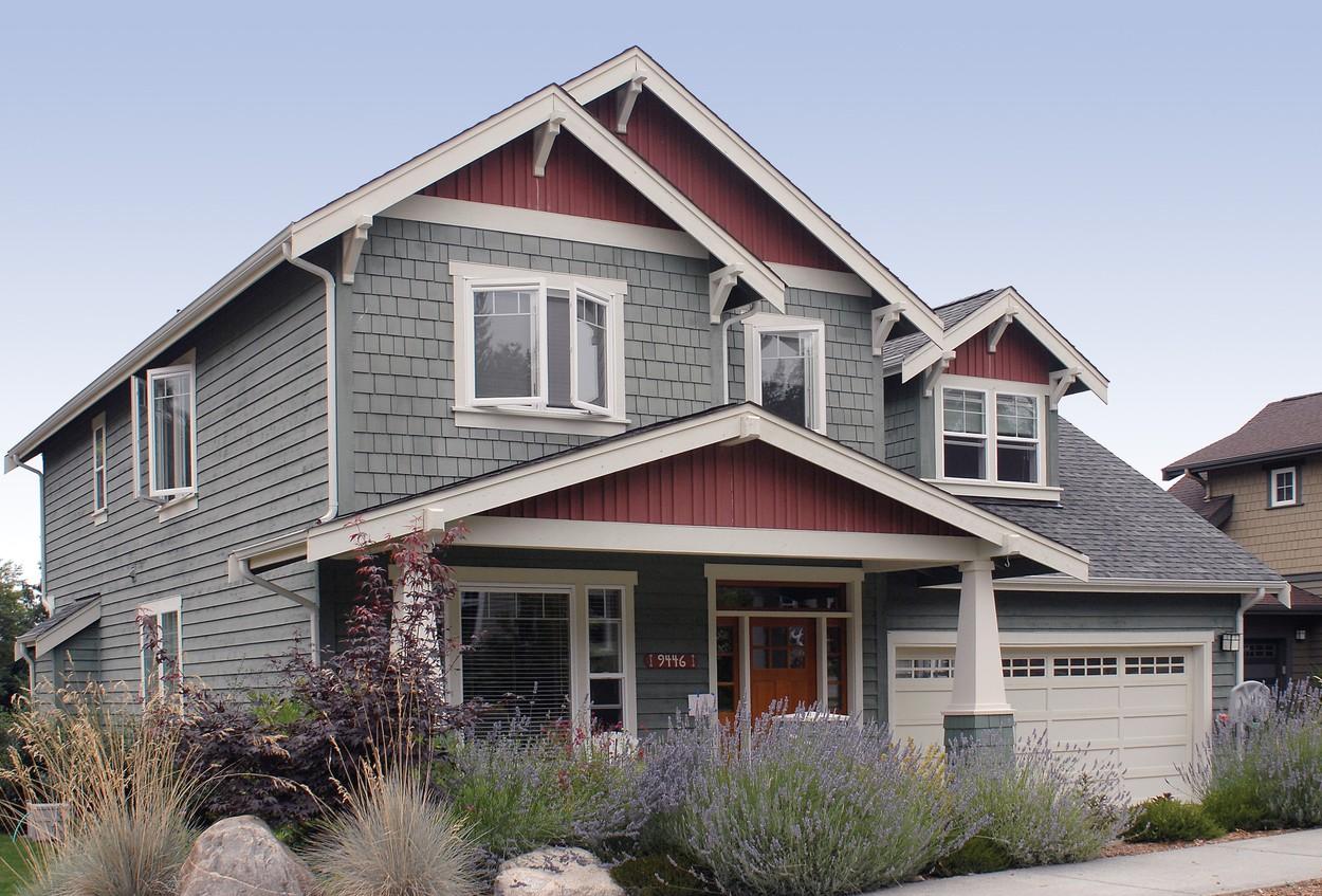 House plan exterior: Two-story Craftsman home with a covered front porch, visible gables with decorative brackets, and a side-entry garage.