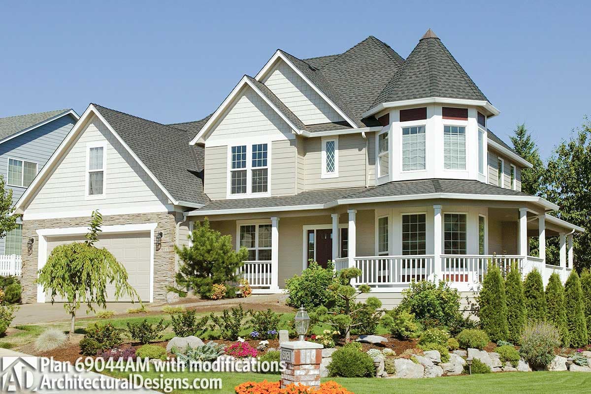 House plan exterior: Two-story home with a turreting bay window, covered porch, gabled dormers, and a side-facing garage.