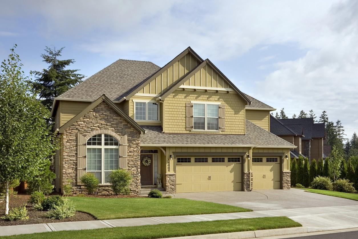 House plan exterior: Two-story home with stone accents, prominent gables, and a three-car garage.