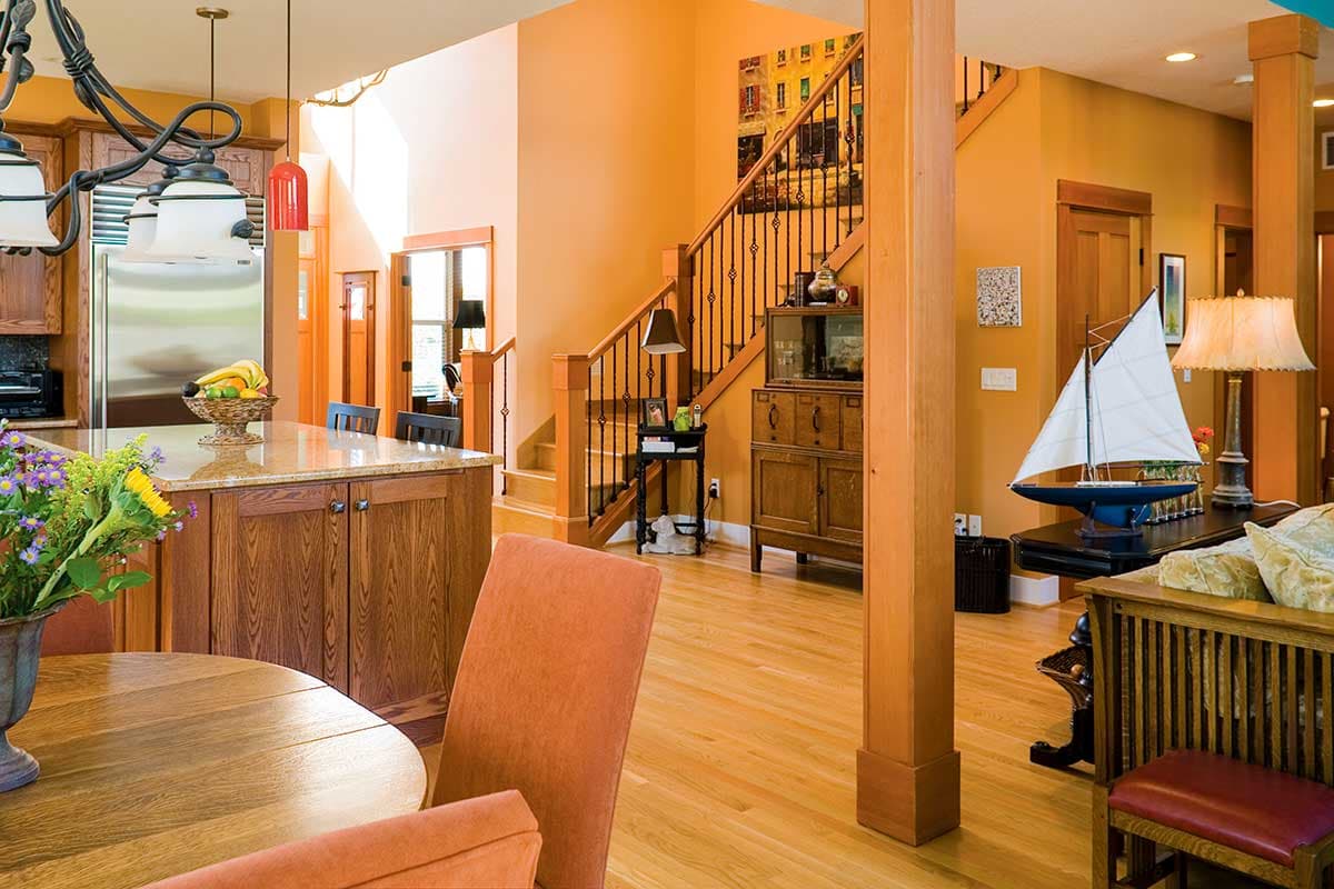 Interior view of a house with a kitchen island, staircase, and an open-concept living area.