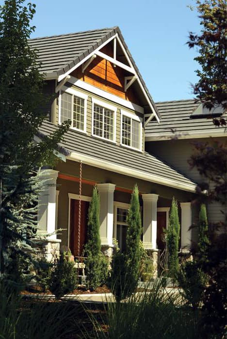 Craftsman style house plan exterior with a covered porch, stone accents, multiple gables, and varied window configurations.