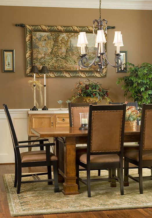 Dining room with a wooden table, upholstered chairs, a buffet, and a tapestry on the wall.